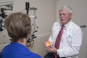 Bradley C. Black, MD showing patient a physical model of the eye
